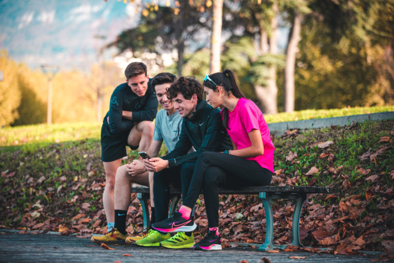 Coureurs qui consultent l’application RunMotion Coach sur un téléphone