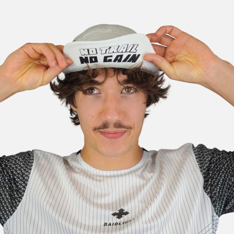 Coureur ajustant la casquette de trail RaidLight Aero Cap