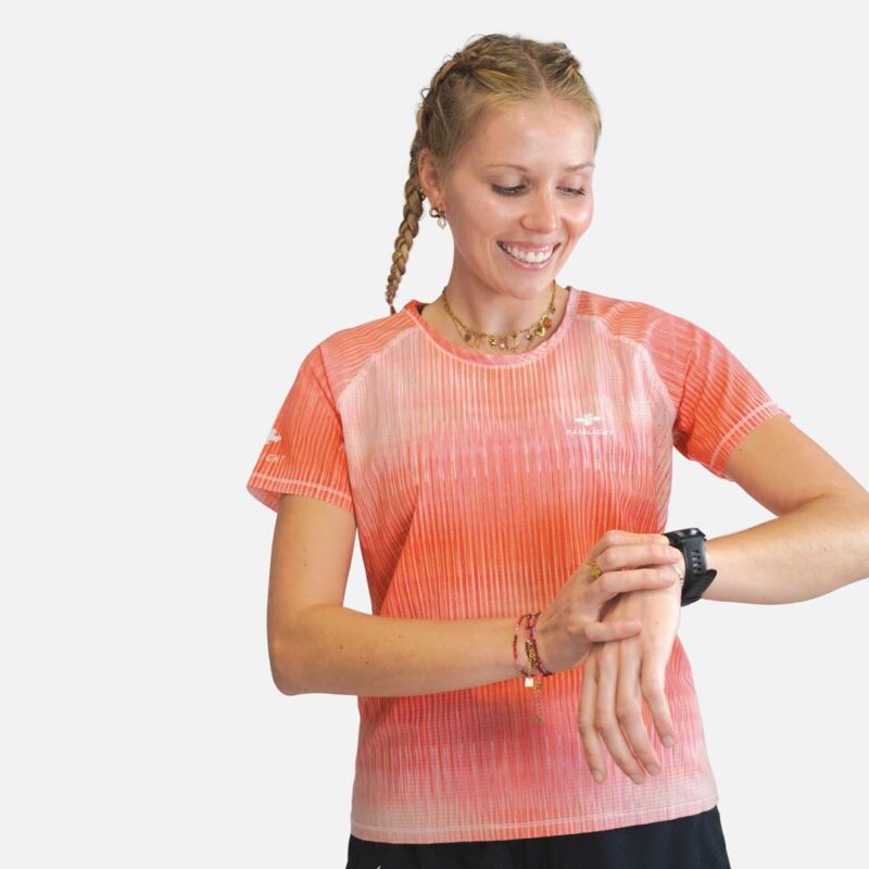 Traileuse regardant sa montre GPS, vêtue du maillot anti-UV RaidLight Ecodry femme